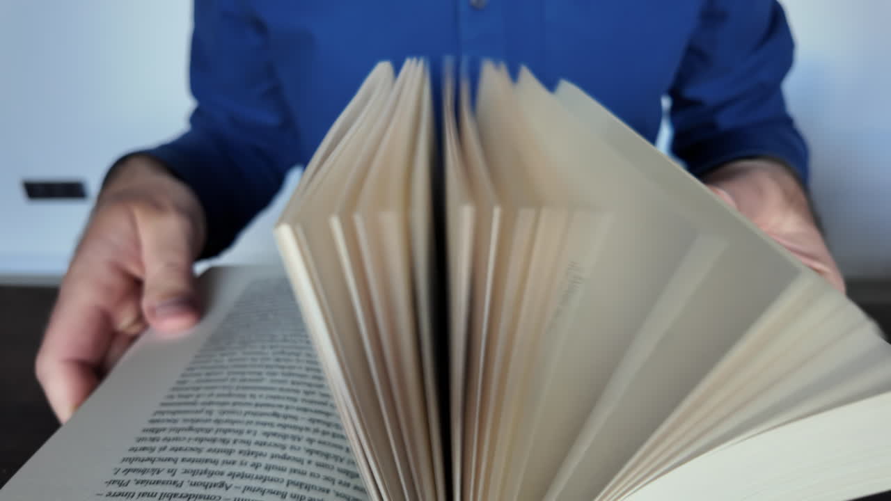 Close-up of a man leafing through a big book