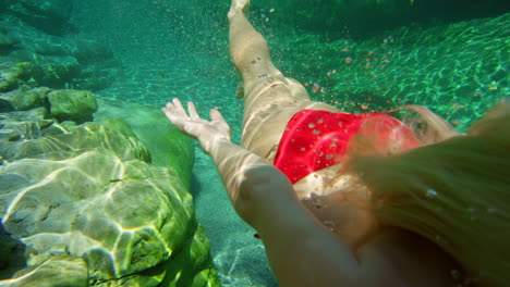 una mujer rubia de vacaciones nadando en un lago