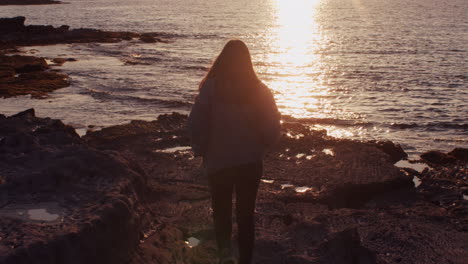 Chica-Hipster-Caminando-En-Cámara-Lenta-Hacia-El-Mar-Al-Atardecer