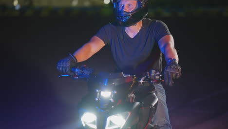 man riding a motorcycle at night