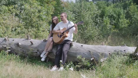 Couple enjoying music with a guitar in nature