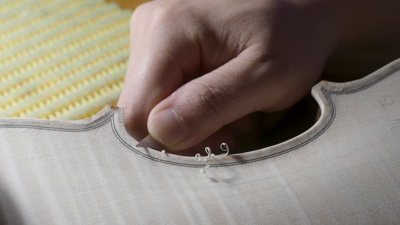 크레모나 (cremona) 의 작업실에서 새로운 클래식 손으로 만든 원시 바이올린을 만드는 장인 (luthier) 의 매크로 클로즈업 (macro close-up)