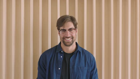 close-up-portrait-of-attractive-young-hipster-man-running-hand-through-hair-laughing-happy-looking-confident-at-camera-handsome-relaxed-caucasian-male