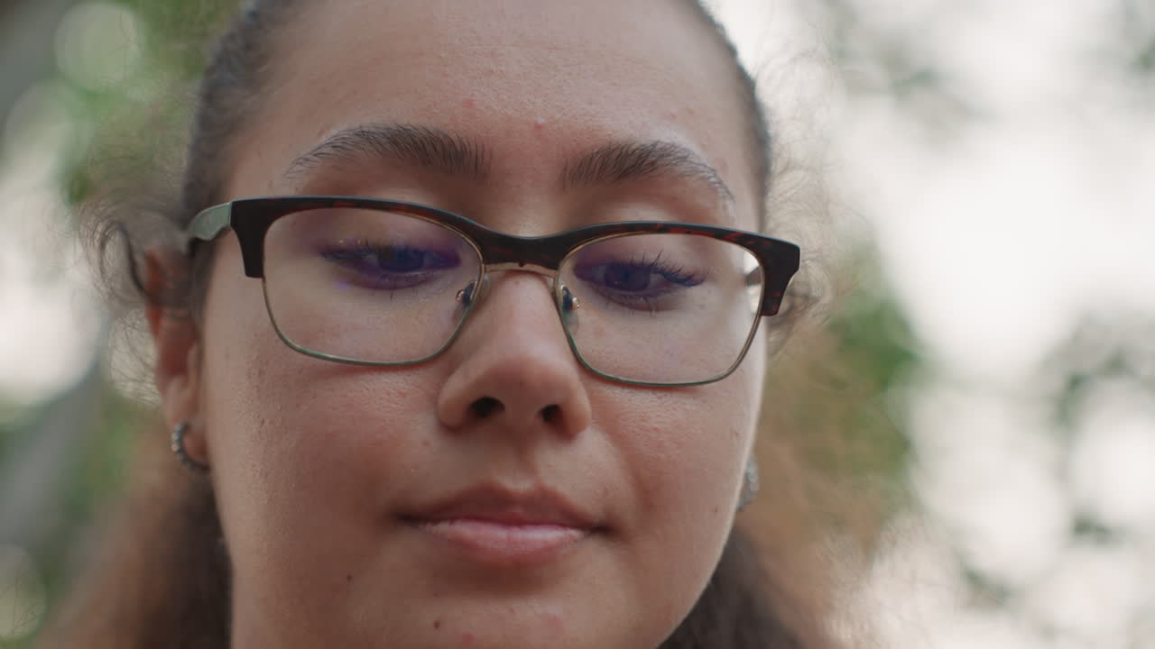 Donna guarda in alto sotto gli alberi. Donna contemplativa guarda verso l'alto tra gli alberi con serena fiducia. Donna pensierosa con un sorriso sottile guarda il cielo attraverso un riflesso e l'atmosfera del crepuscolo