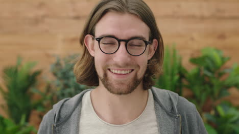 portrait-of-cute-young-geeky-man-puts-on-glasses-smiling-cheerful-looking-at-camera