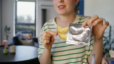 woman applying gold eye patches and nail file