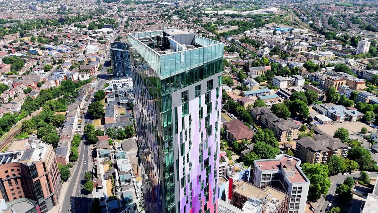 High-altitude aerial pass over Saffron Tower, capturing the tower’s vivid facade, contemporary design, and the buzzing cityscape of Croydon below.