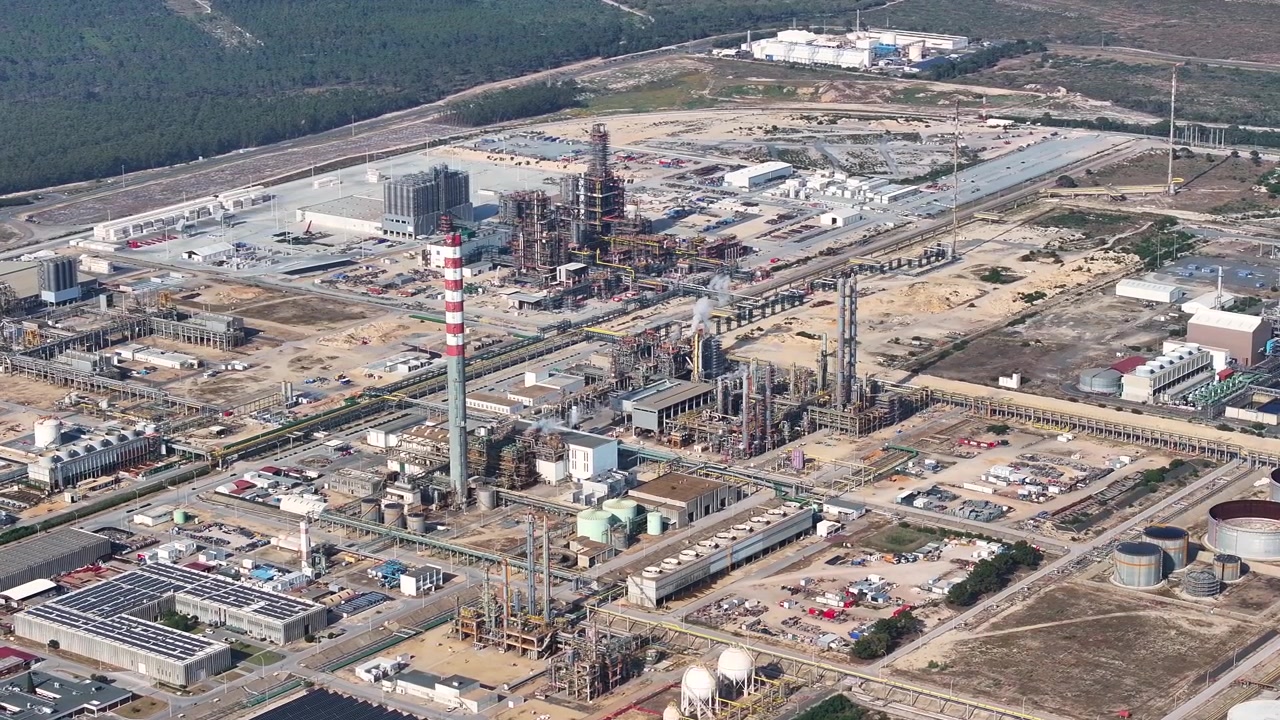 Questa vista aerea cattura la vivace attività in una grande raffineria di petrolio, mostrando la lavorazione del greggio e la produzione di carburante in un'infrastruttura energetica essenziale.