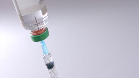 primer plano del vial de insulina y la jeringa sobre un fondo gris con espacio para copiar, cámara lenta