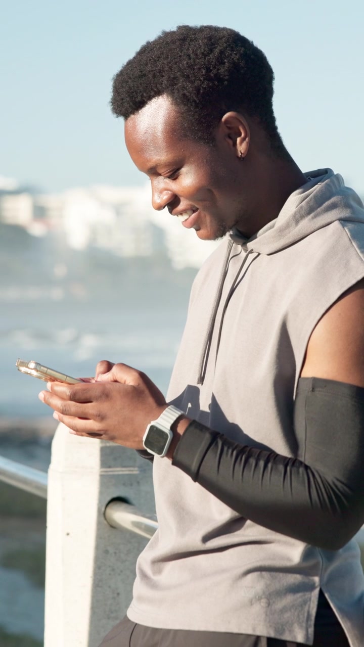 Giovane Uomo che Usa lo Smartphone all'Aperto in Riva all'Oceano