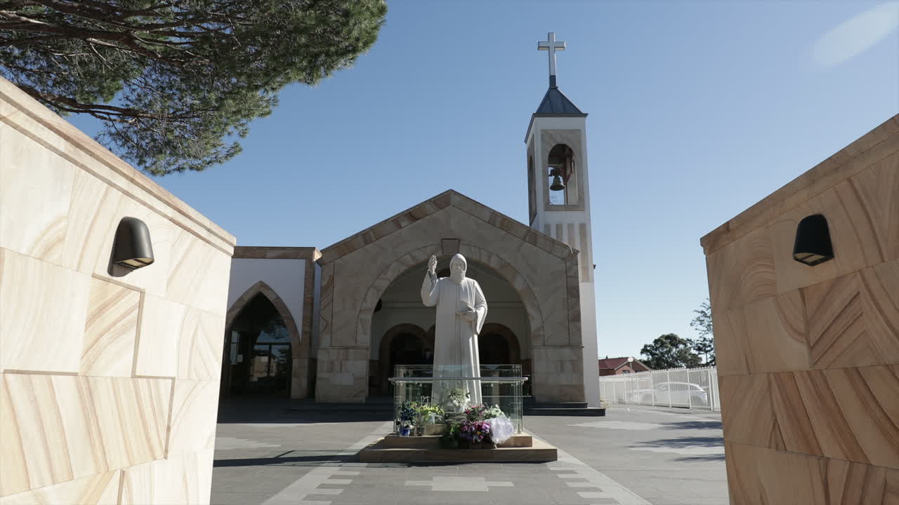 Church with bell tower - Jesus statue surrounded by flowers