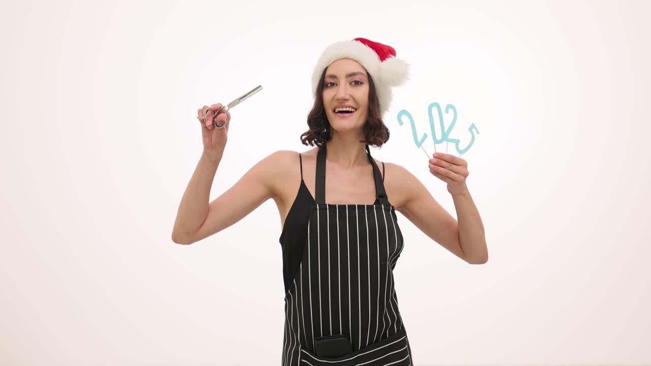 Woman with Santa hat and apron holding 2023 sign and scissors