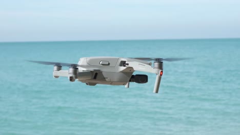 side view of drone hovering with ocean and blue sky in background