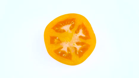오렌지색 토마토의 위쪽 전면. 부분. 색 배경에 고립 된 회전 테이블에서 회전. 근접. 매크로.