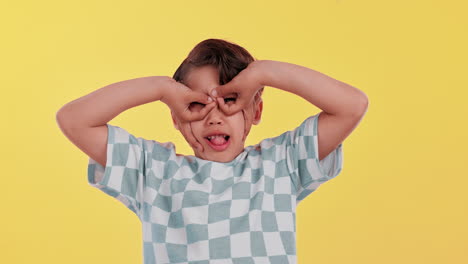a young boy making silly faces on a yellow background