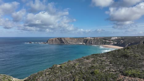 Long-aerial-shot-flying-over-a-beautiful-coastal-area-with-hills,-cliffs-and-a-secluded-bay