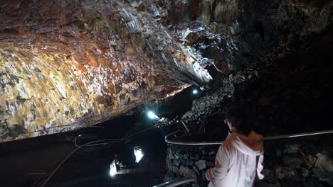 woman walks down stairs in algar do carvao caves