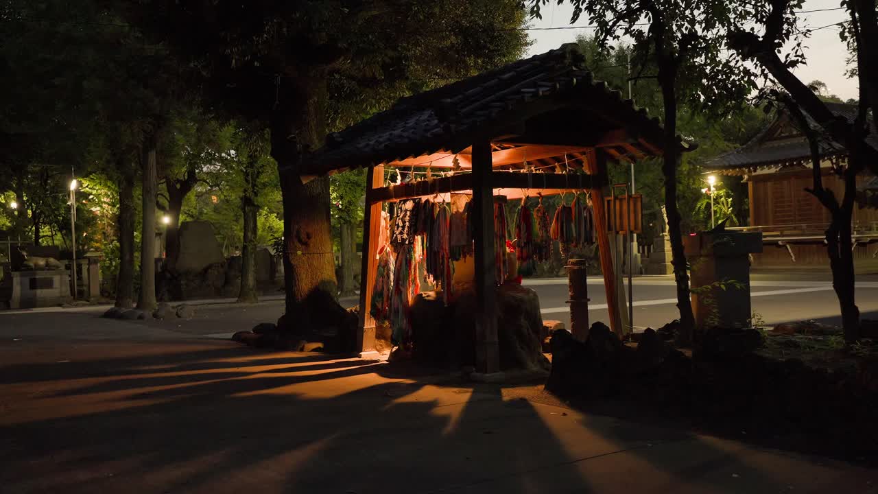 Ushijima Shrine: an illuminated stone ox statue with a red cloth and senbazuru at night