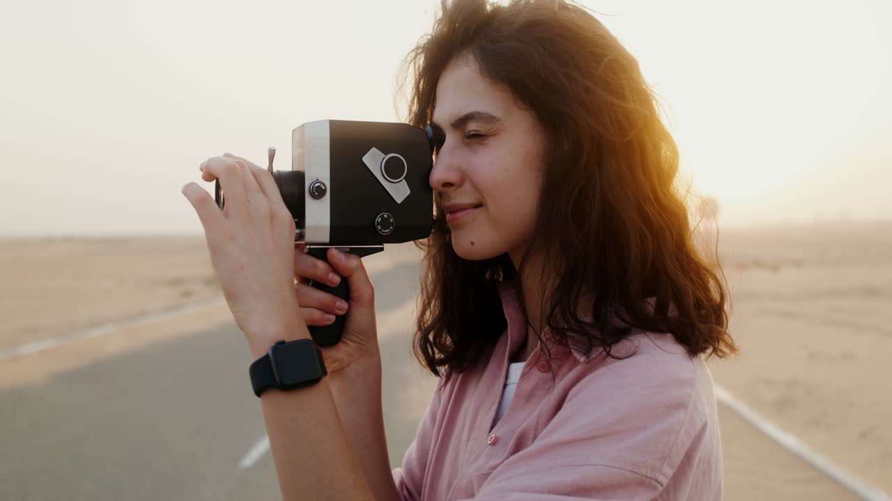 mujer con cámara vintage en el paisaje del desierto