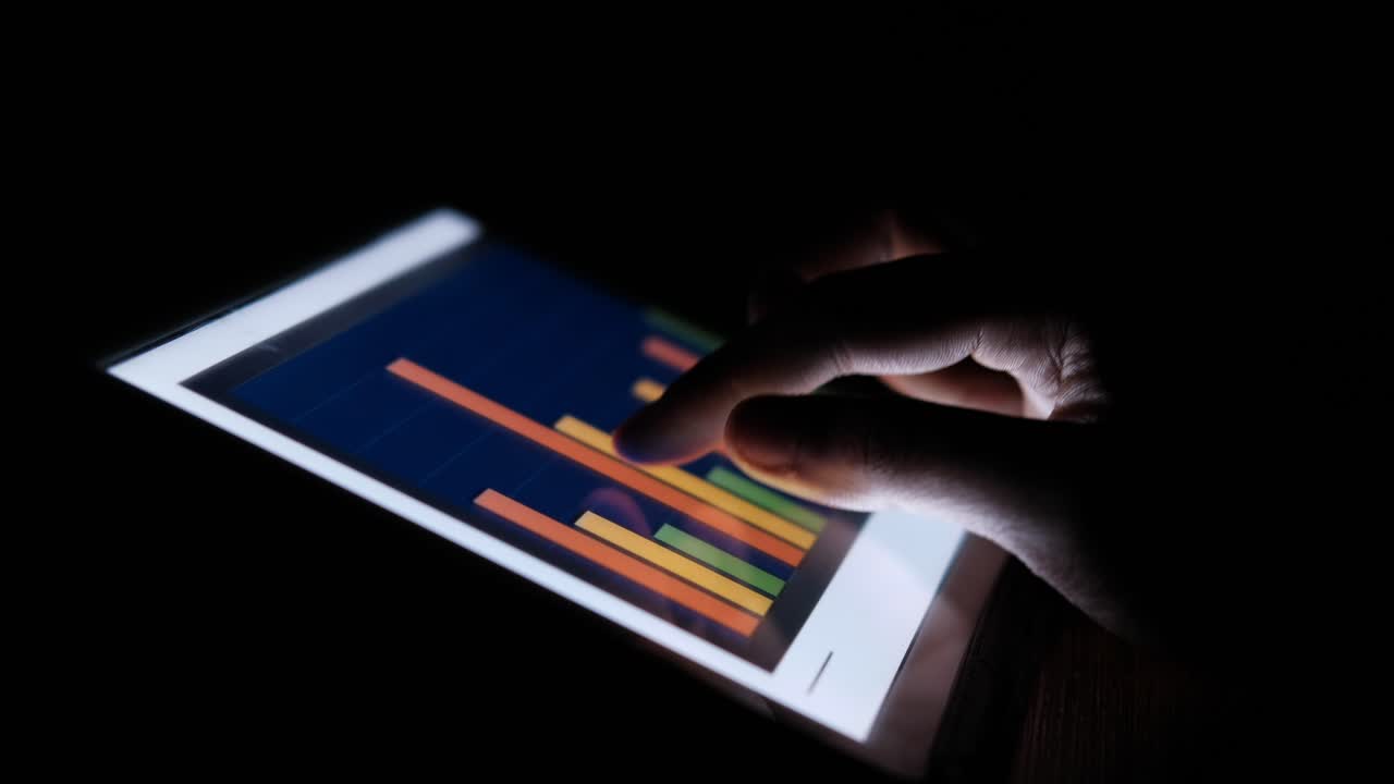 Analyzing Data on a Tablet at Night