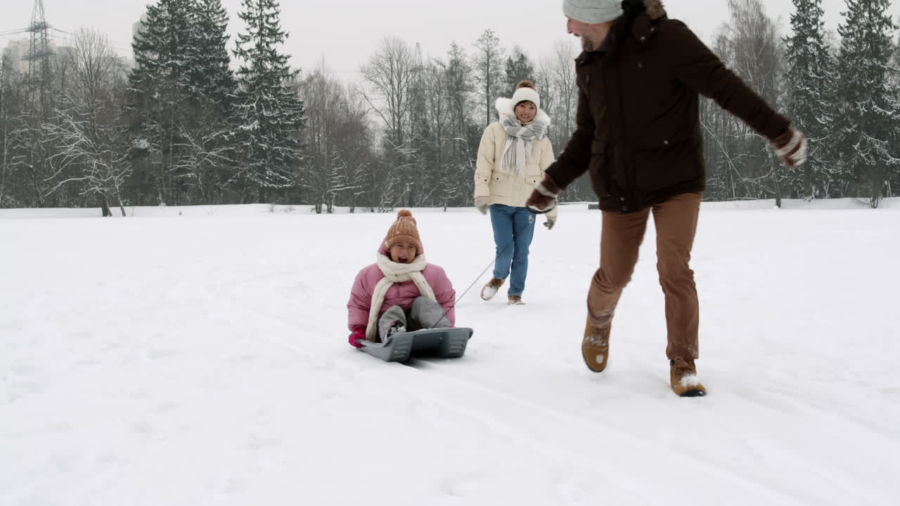 diversión de trineo en familia en la nieve