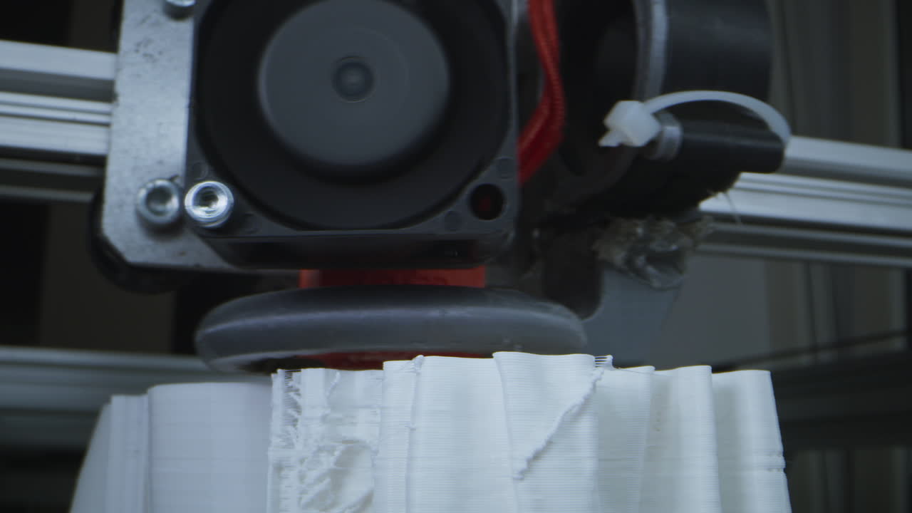 Close-up of a 3D printer in action, creating a white object