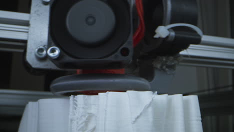 close-up of a 3d printer in action, creating a white object
