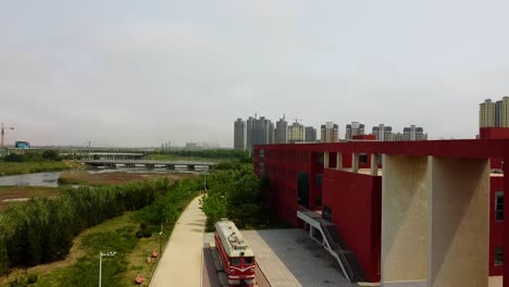 Cinematic-aerial-descending-view-of-antique-locomotive-at-Beijing-Jiaotong-University-Weihai-campus,-China