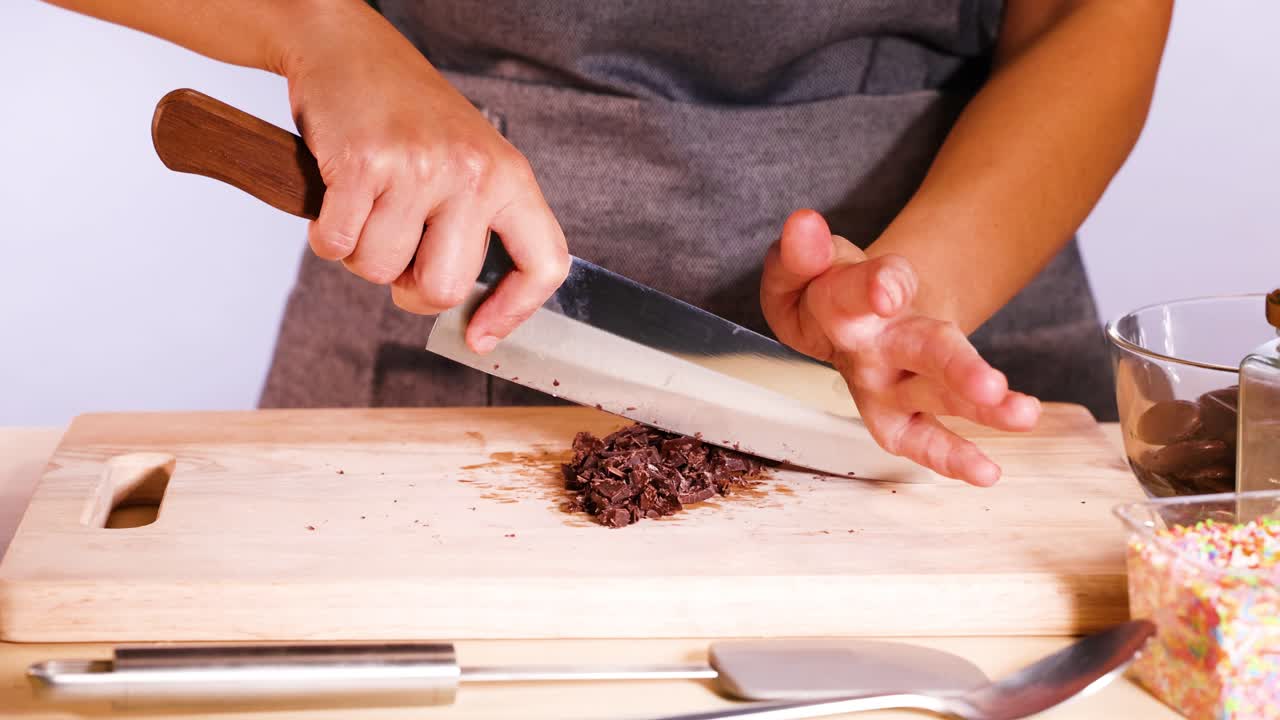 Persona che taglia dischi di cioccolato con un coltello