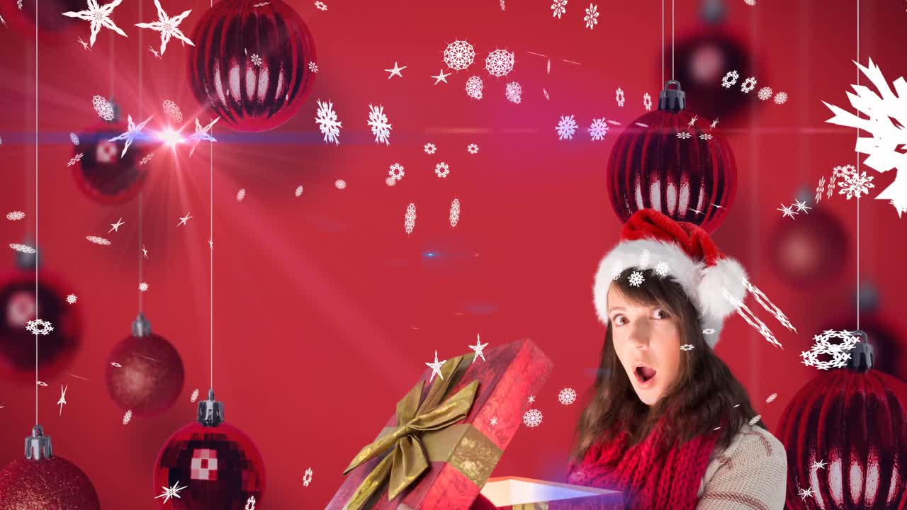 animación de nieve cayendo sobre feliz mujer caucásica con sombrero de santa manteniendo presente