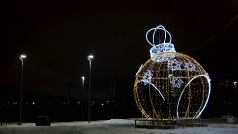 gigante ornamento de navidad iluminado en un parque de la ciudad por la noche