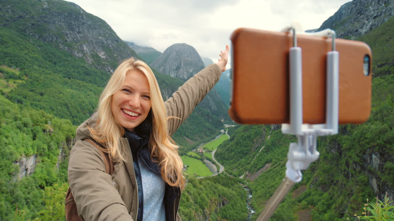 mujer tomando una selfie en las montañas noruegas