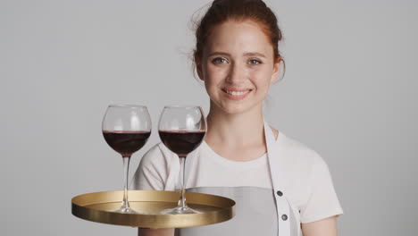 Redheaded-waitress-in-front-of-camera-on-gray-background.