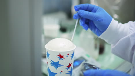 scientist with blue gloves doing experiments with rising styrofoam in chemical laboratory of polyurethane factory in slowmo