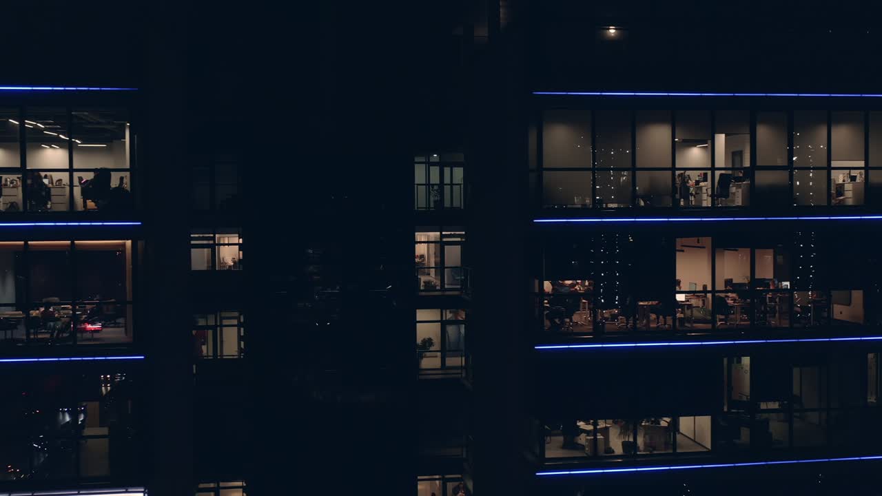 ventanas de la oficina con personas en el centro de negocios por la noche