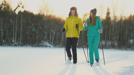 Im-Winterwald-Fahren-Bei-Sonnenuntergang-Ein-Mann-Und-Eine-Frau-Ski-Und-Schauen-Sich-In-Zeitlupe-Die-Schönheit-Der-Natur-Und-Der-Sehenswürdigkeiten-An.