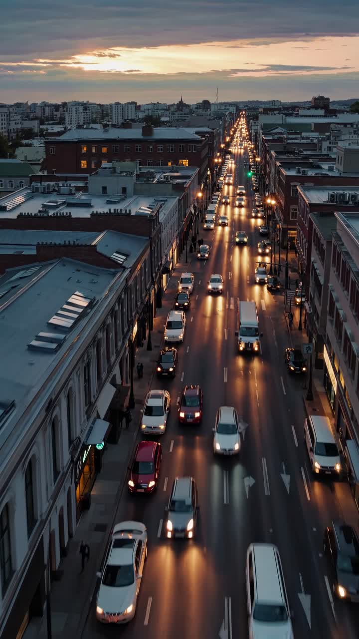 Aerial view of a bustling city street at dusk, showcasing a cinematic video style with glowing