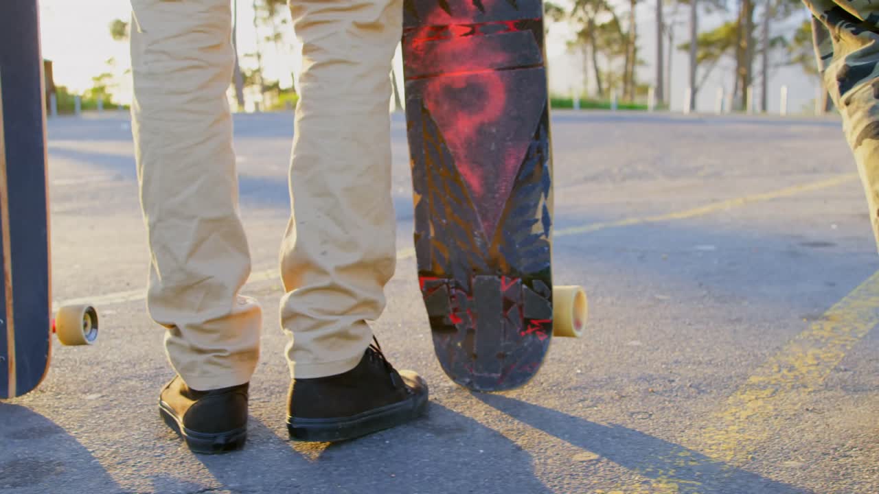 sección baja de jóvenes patinadores de pie con patineta en la carretera del país 4k