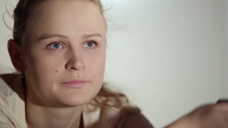 young woman is watching an interesting film on tv