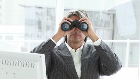 Mature-businessman-looking-through-binoculars