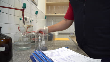 asistente de laboratorio toma muestras de agua en el laboratorio