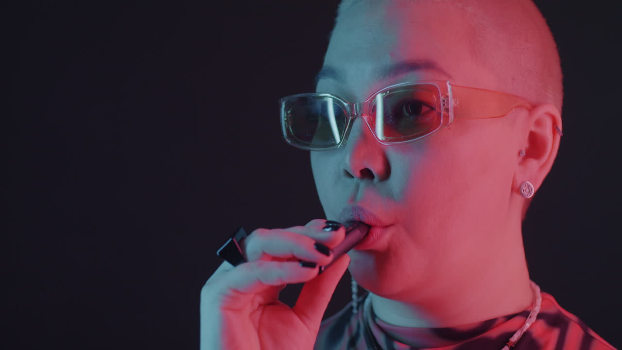 Stylish Woman Vaping in Neon Lighting