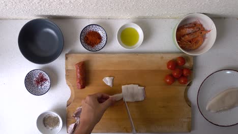 male chef cutting squid tube into rings, overhead cooking video