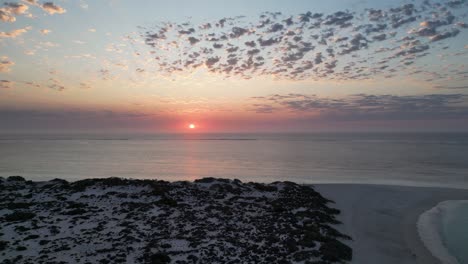 bahía australiana con el sol poniéndose sobre el mar