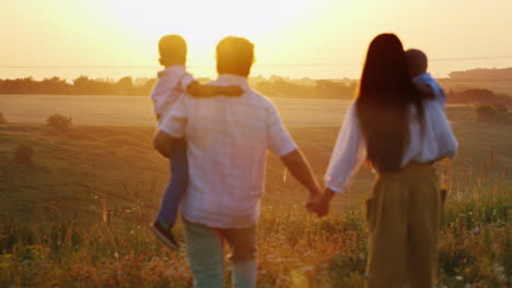 una joven familia campesina con niños va a encontrarse con la puesta del sol