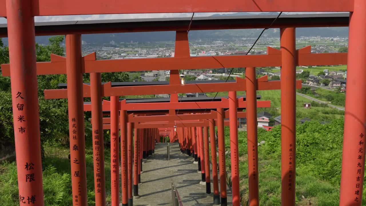 Hidas, elokuvamainen kävely kivisiä portaita pitkin punaisten torii-porttien läpi Japanin maaseudulla