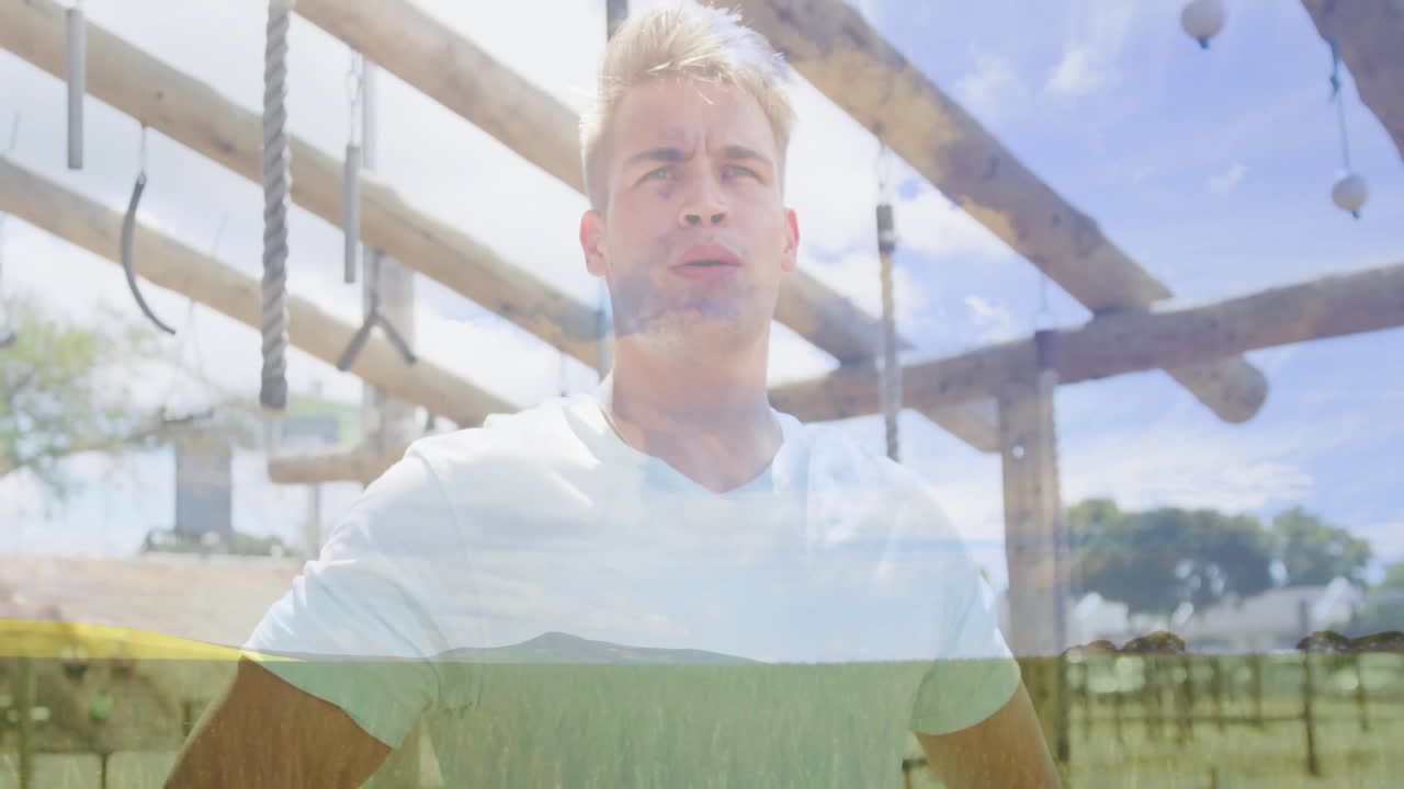 Standing outdoors, man in white shirt looking at ropes and beams overhead