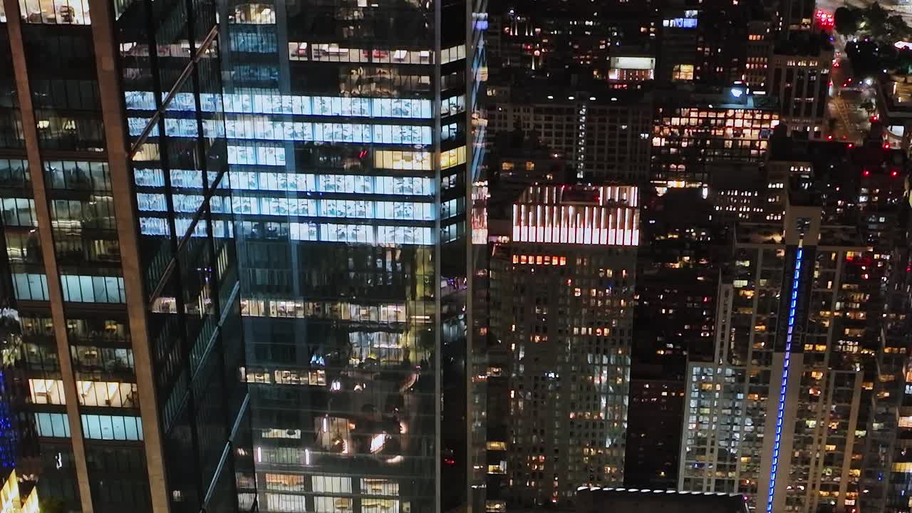 Bright city lights illuminate New York skyline during night aerial view