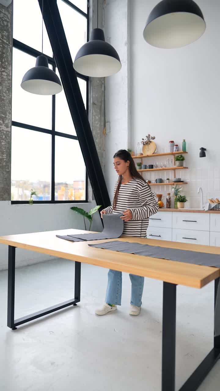 mujer arreglando la tela en una mesa en una cocina moderna