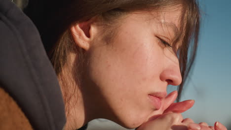 close-up of a girl resting her head on her hands, her expression deeply sorrowful and contemplative. the image captures a moment of disconsolation, filled with melancholy and introspection